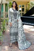 Woman in a black and white patterned outfit standing outdoors with a piano in the background